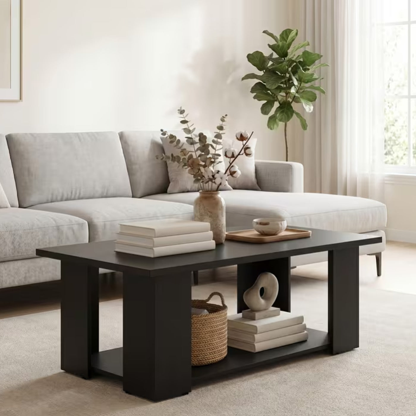 Halden black two tier coffee table with an open lower storage shelf in front of a pale sectional