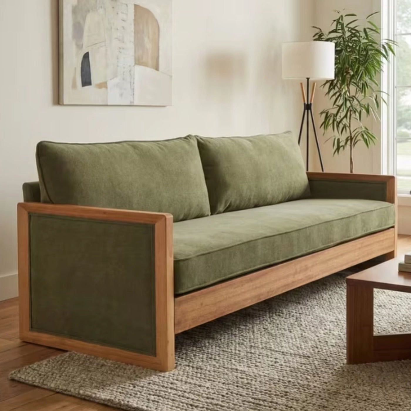 Marlowe green chenille three seater sofa with an exposed wood frame on a woven rug