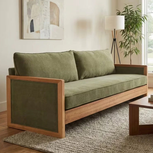 Marlowe green chenille three seater sofa with an exposed wood frame on a woven rug